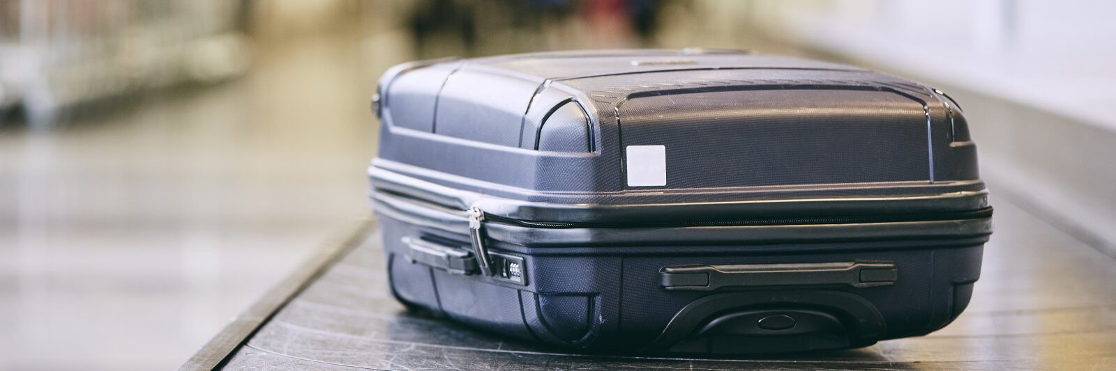 Suitcase sitting on conveyor belt on airport